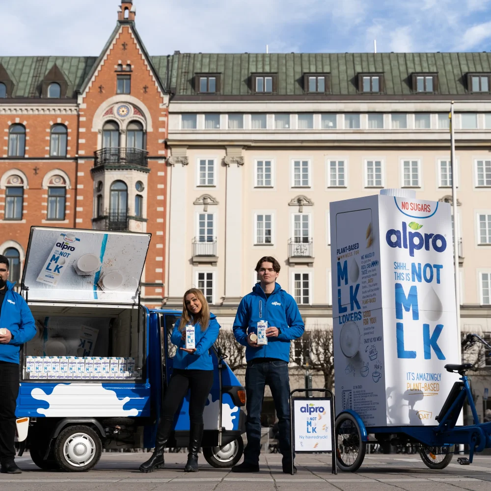 Vår eventpersonal står framför ett Alpro-brandat eventfordon