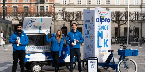 Vår eventpersonal står framför ett Alpro-brandat eventfordon