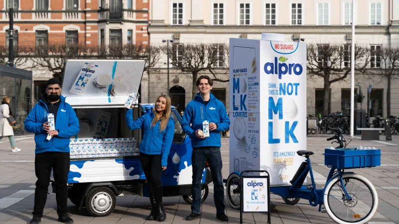 Vår eventpersonal står framför ett Alpro-brandat eventfordon